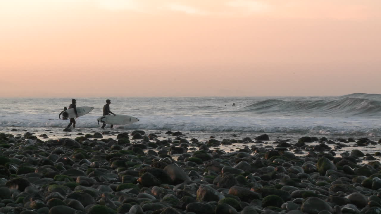 벤투라 캘리포니아의 서퍼 포인트에서 파도 속으로 노를 젓는 서퍼들