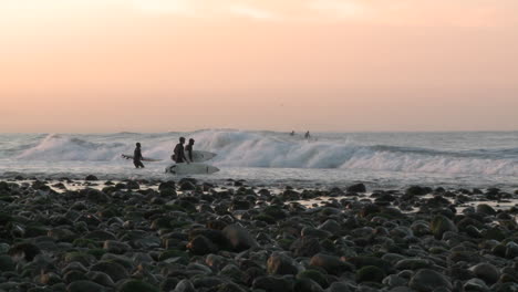 surfers paddling out at into the waves at surfers point in ventura california