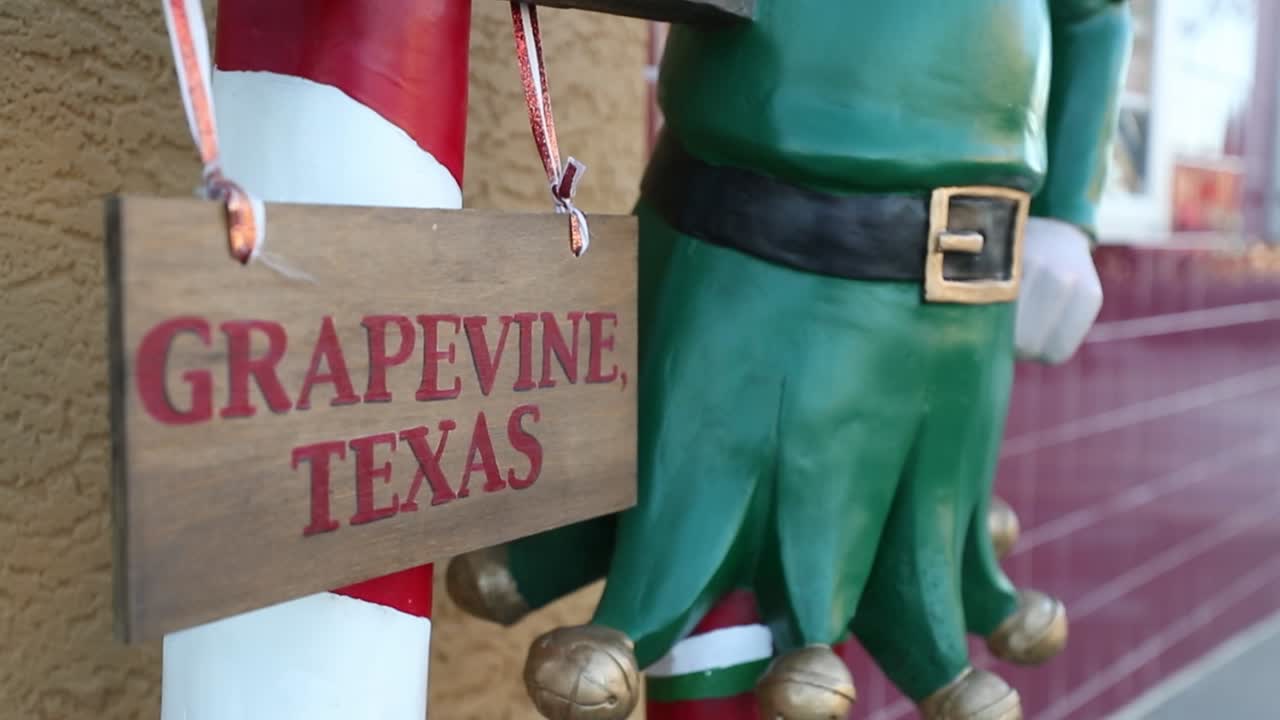 Elf statue with a sign reading &amp;quot;North Pole&amp;quot; and a smaller sign reading &amp;quot;Grapevine Texas