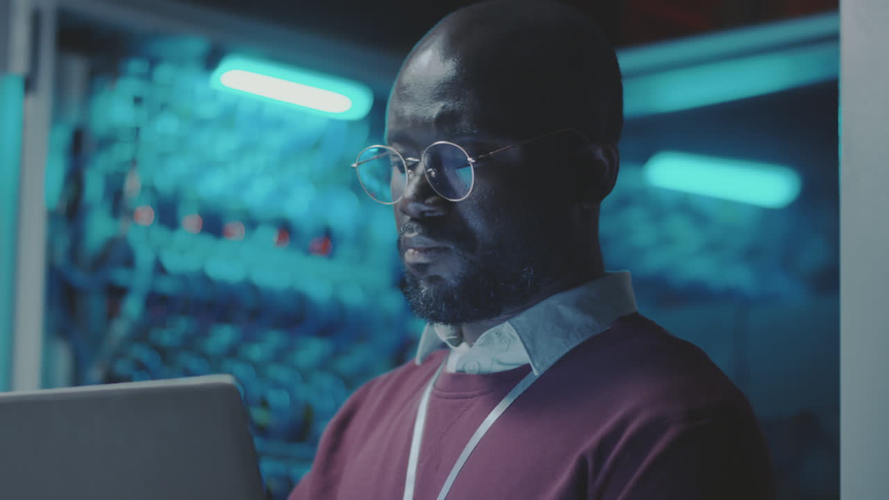 IT professional working on a laptop in a data center