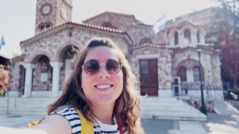 smiling woman traveler posing at a historic greek landmark