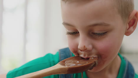 niño feliz degustando delicioso pudín de chocolate usando cuchara disfrutando de golosinas caseras en la cocina