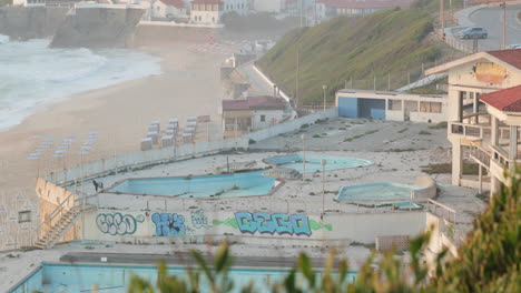 Abandoned-Swimming-Pools-With-Sao-Pedro-de-Moel-Beach-In-The-Background-In-Leiria,-Portugal