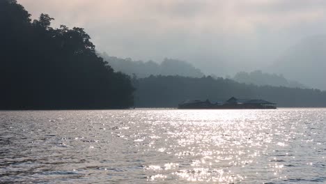 sun rising over a tranquil forested lake