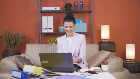 Die-Junge-Frau-Im-Homeoffice-Freut-Sich-über-Das,-Was-Sie-Auf-Dem-Laptop-Sieht.