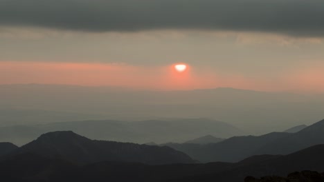 unique alpine sunrise as sun disappears behind clouds, misty conditions, time lapse