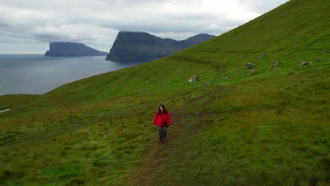 woman hiking in majestic scenery on kalsoy, faroe islands