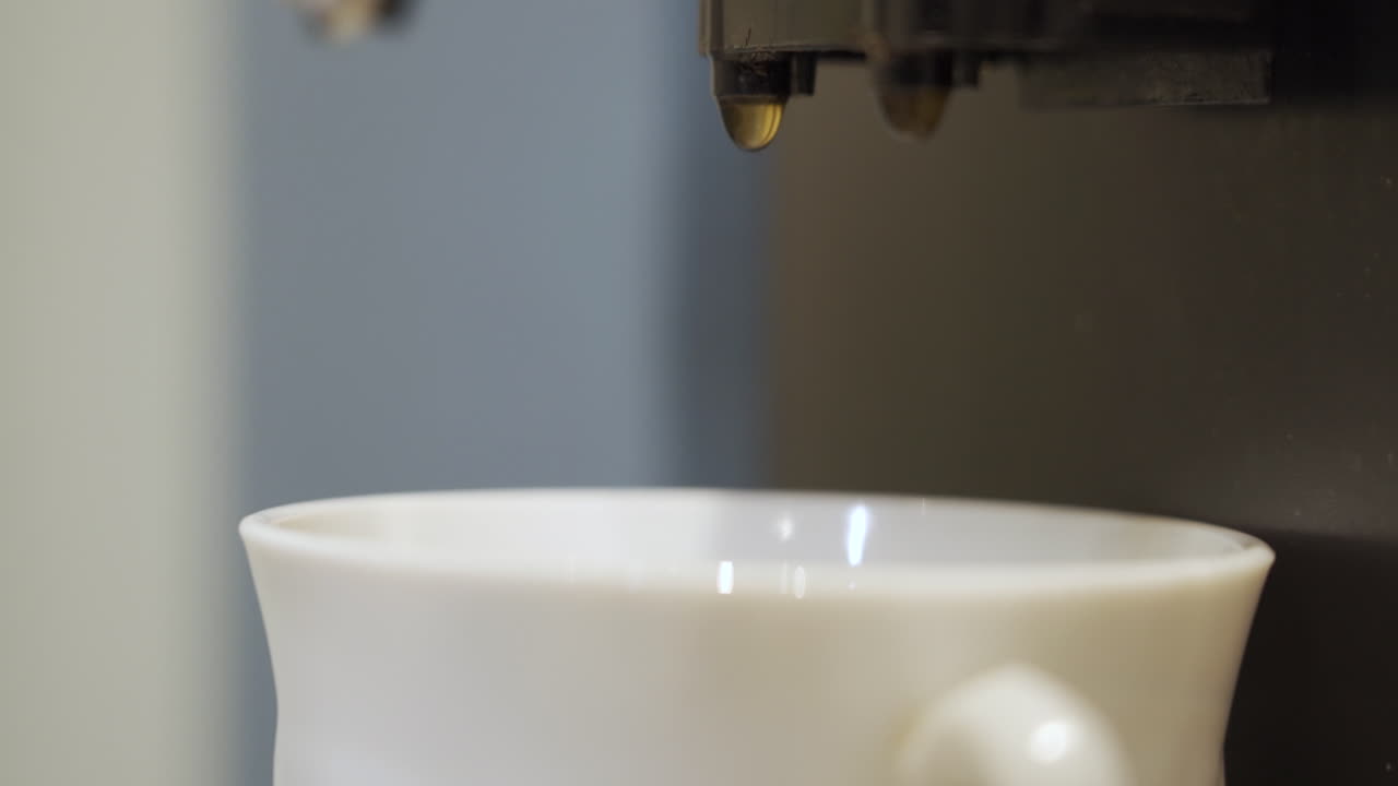 커피 한 방울 이 커피 기계 에 매달려 있다