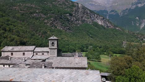 	Aerial-view-of-the-historic-Novalesa-Abbey,-a-Benedictine-monastery-nestled-in-the-lush-landscape-of-Piedmont,-Turin,-Italy