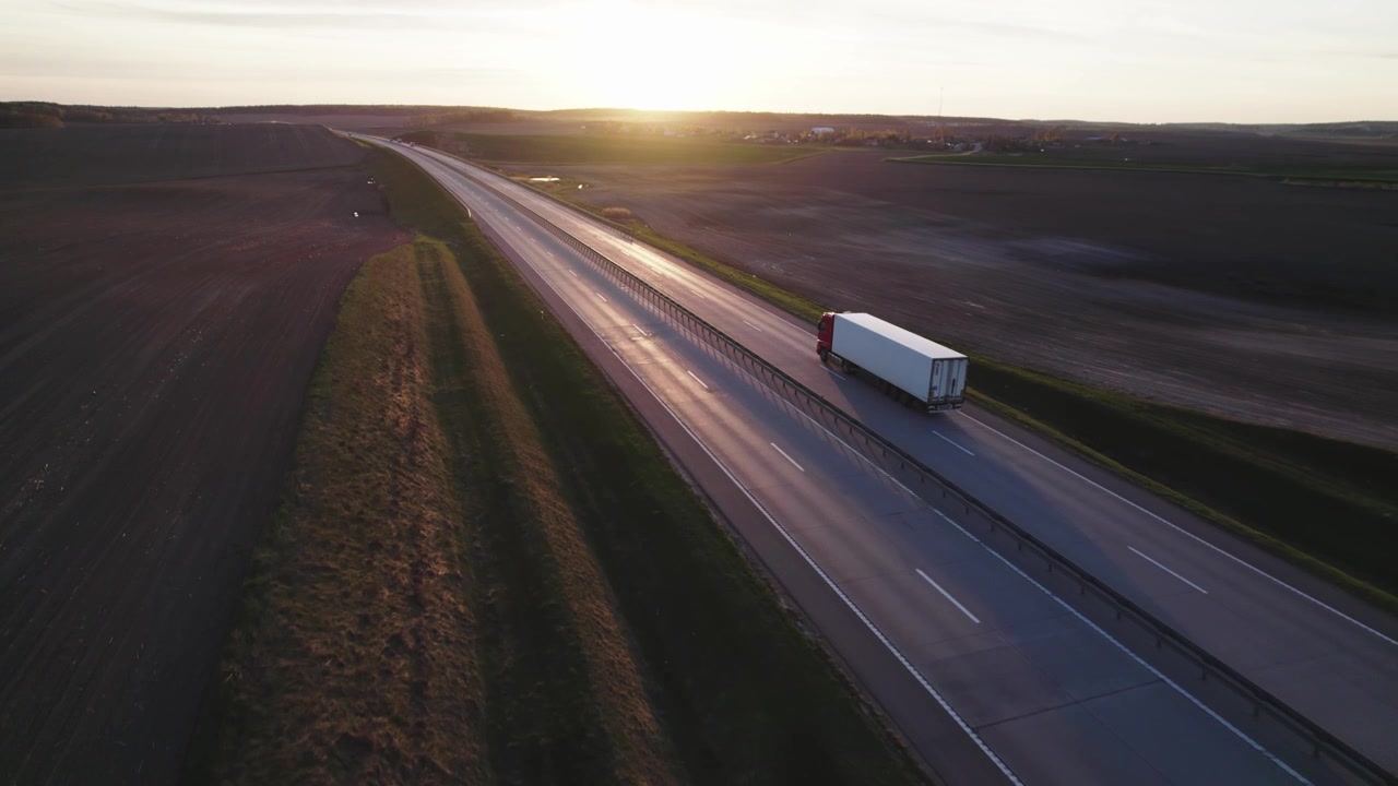 Vista aerea di un tir che guida in autostrada al tramonto
