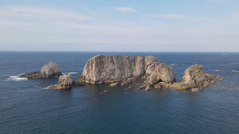 zoom in of waves breaking on rocks in the blue sea on a sunny day