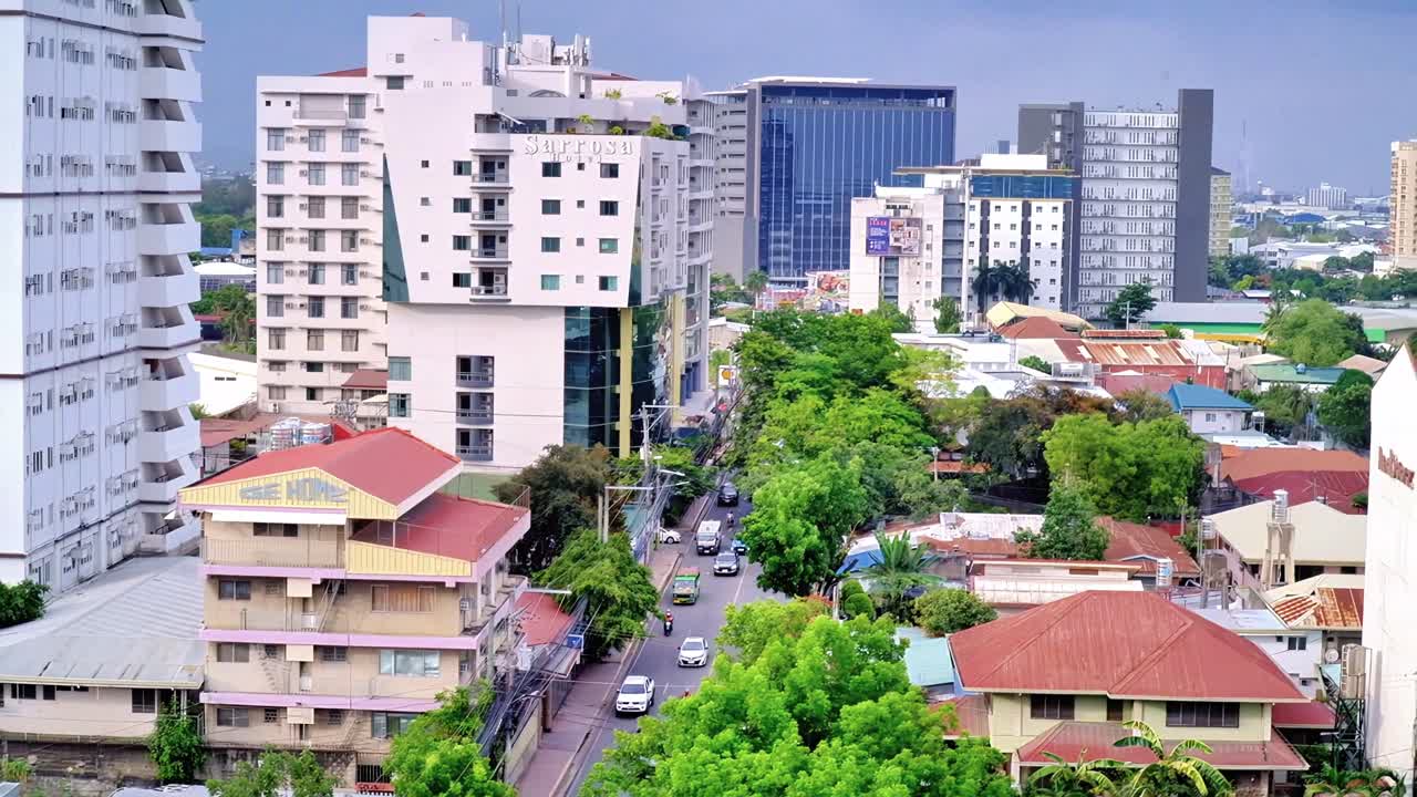 Editorial footage showing vehicles traversing a side street in uptown Cebu City amid a plethora of condominiums, hotels and residential as well as business office spaces.