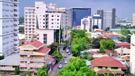 editorial footage showing vehicles traversing a side street in uptown cebu city amid a plethora of condominiums, hotels and residential as well as business office spaces.