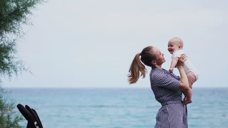 at the seashore, the mother throws her son into the air playfully, fostering a cheerful atmosphere by the waves. a young family savors their time by the sea