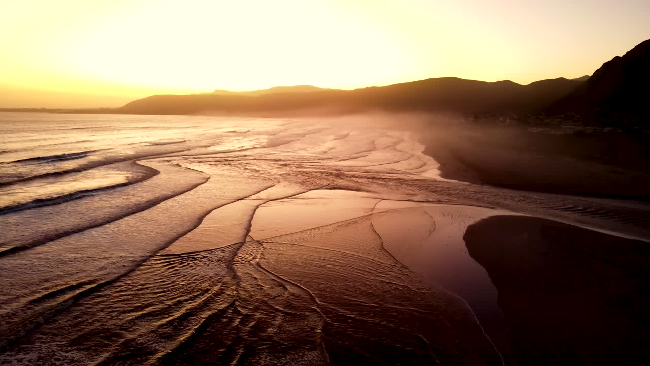 vista aérea de retirada sobre la playa con la desembocadura del río klein rompiendo en el océano