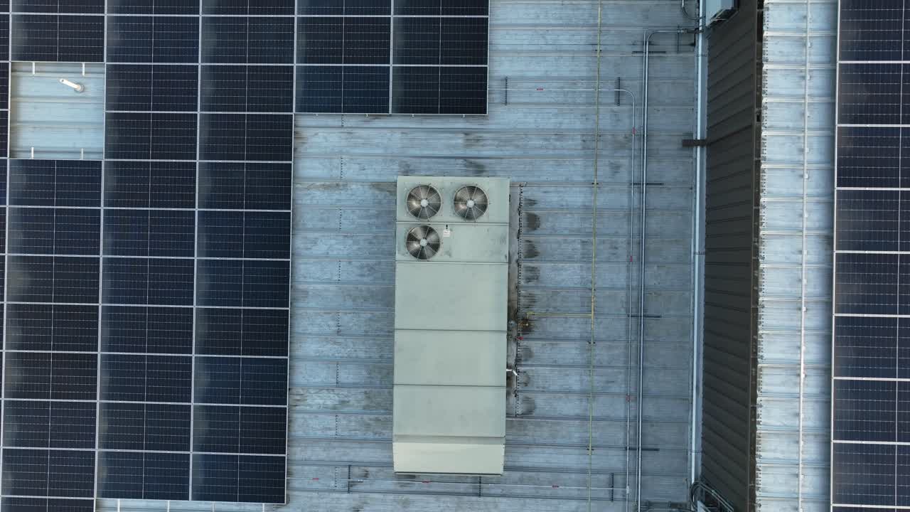 Moderne solpaneler og roterende ventilatorer på bygningstag i Amerika. Stigende luftoptagelse fra top-ned. Produktion af kølig luft og grøn energi i USA.