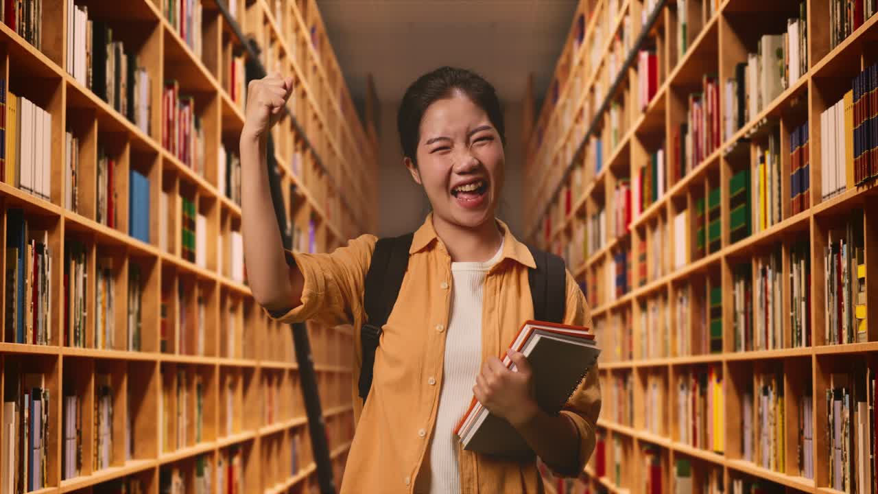 Asian Woman Student With A Backpack And Some Books Screaming Goal Celebrating Succeed Learning In The Library