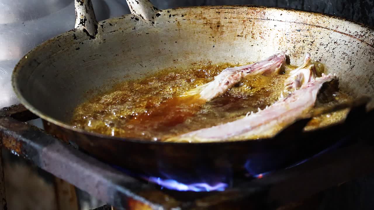 Sequenza di pesce che frigge in olio caldo sul fornello