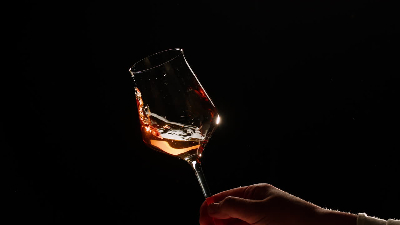 Rose Orange or white wine bottle and glass against a sunset in a peaceful vineyard, pouring of ecological natural wine. Cheers, hands with wine glasses, drinking alcohol.