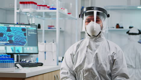 portrait of experienced scientist man in coverall smiling at camera