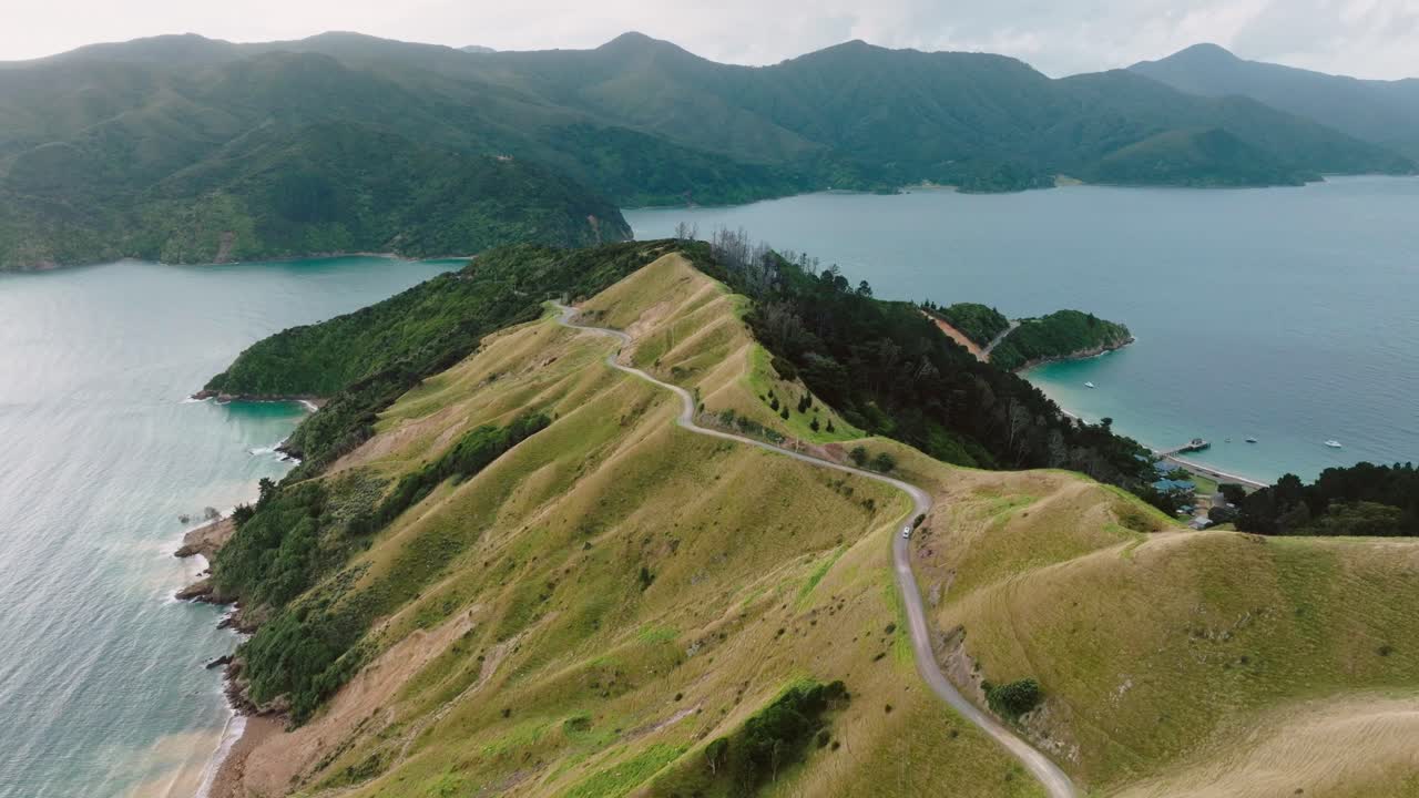 Aerial view of campervan traveling along peninsula road of Te Aumiti French Pass with beautiful ocean views and D'Urville Island in Marlborough Sounds, South Island of New Zealand Aotearoa