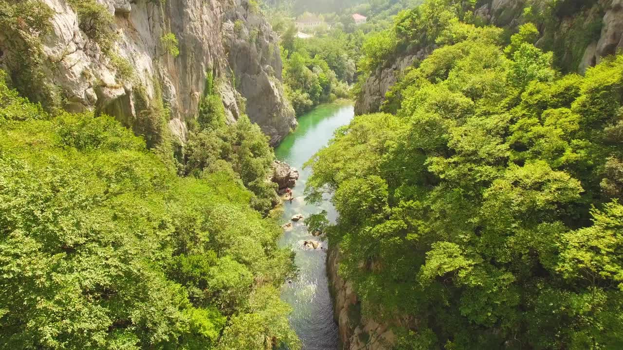 Drone che vola sopra fiume, natura verde e rocce