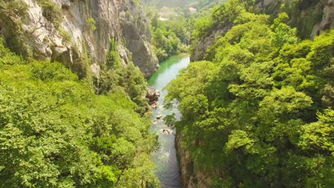 drone flying over river, green nature and rocks