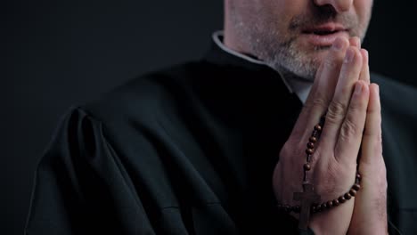 catholic priest praying with rosary in hands, faith and belief, catholicism