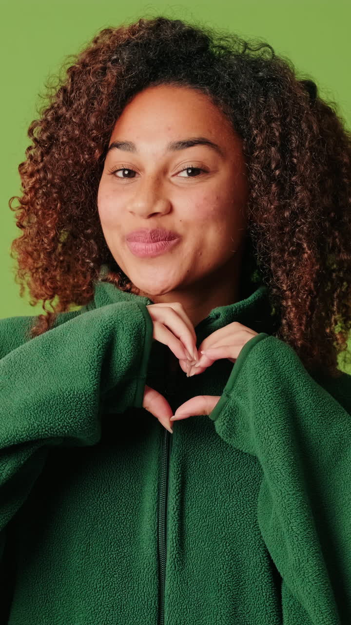 Happy Young Woman Making Heart Shape with Hands