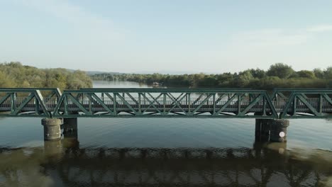 green metal truss bridge over calm river