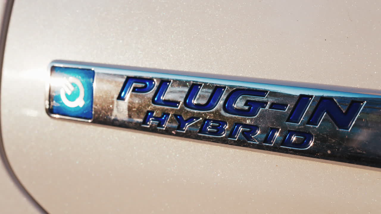 Shining close up of a plug in hybrid badge on a car under sunlight