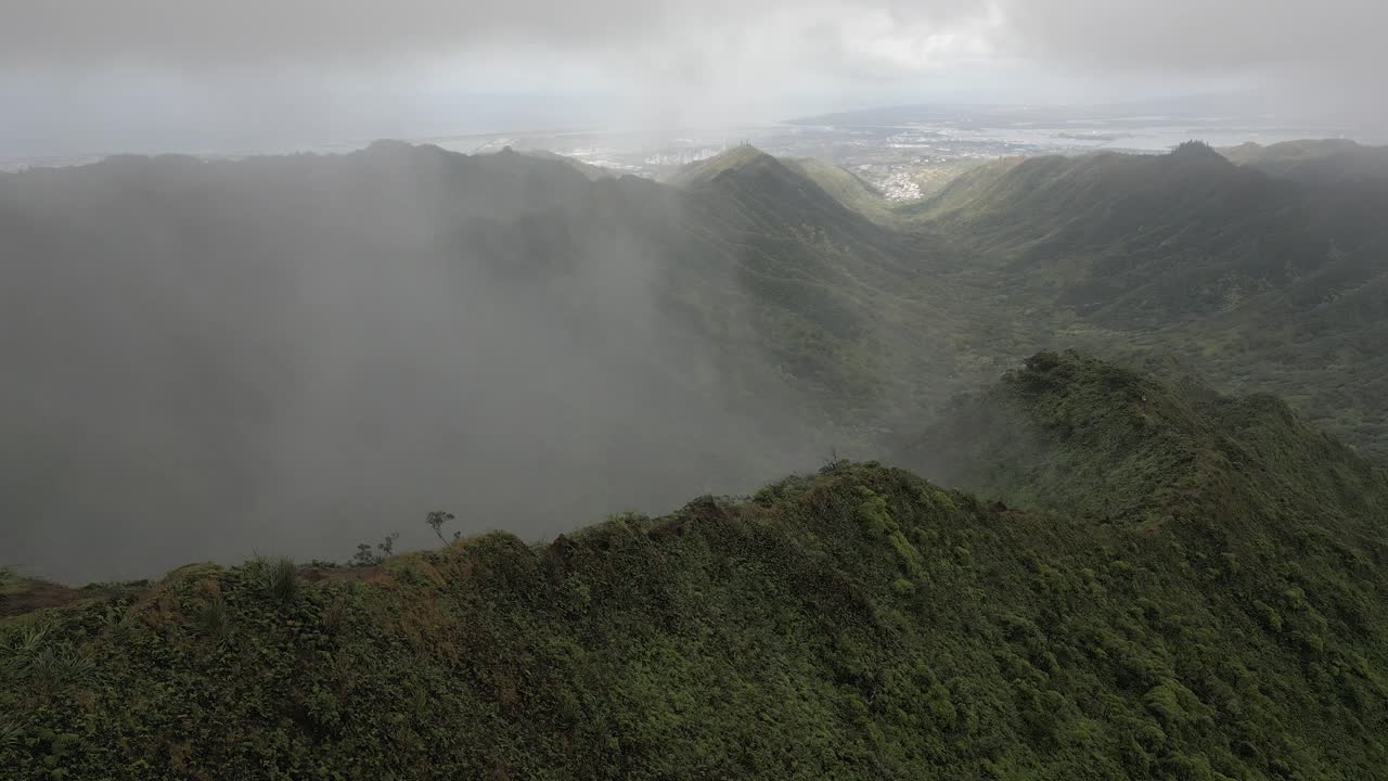 la niebla se eleva por el valle de moanalua, pearl harbor en honolulu se ve muy por debajo
