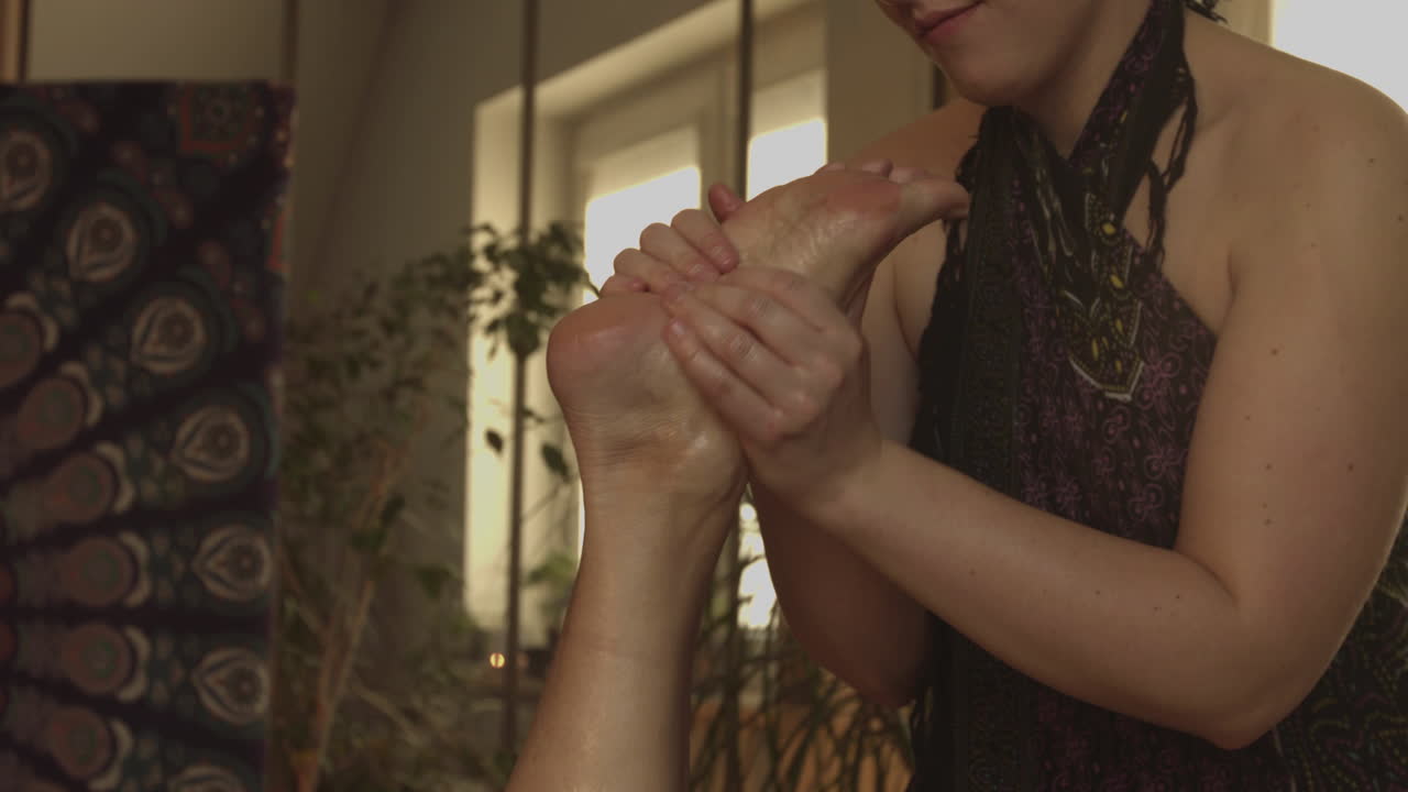 A professional masseuse massaging a woman's foot