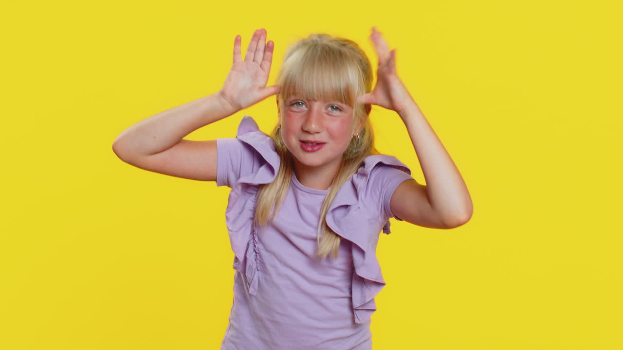 Cheerful funny bully child girl showing tongue making silly faces fooling around joking teasing