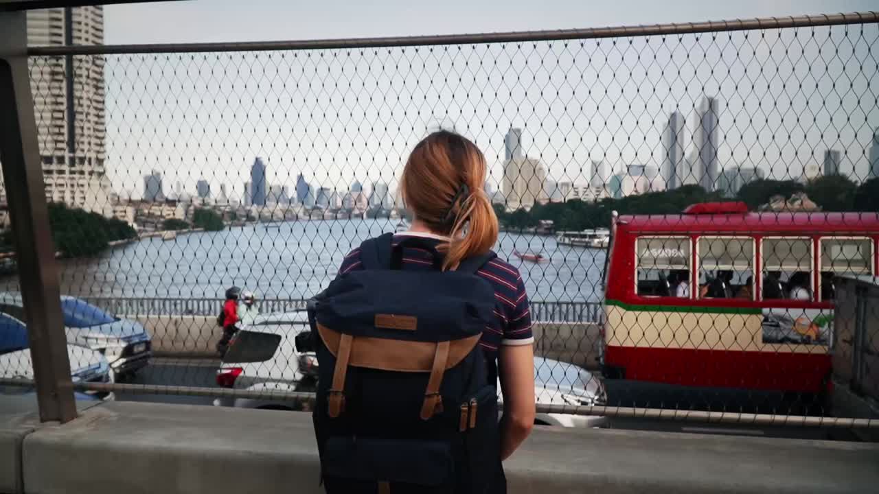 una joven estudiante con una mochila de pie sobre el puente chao phraya sky park en bangkok, tailandia