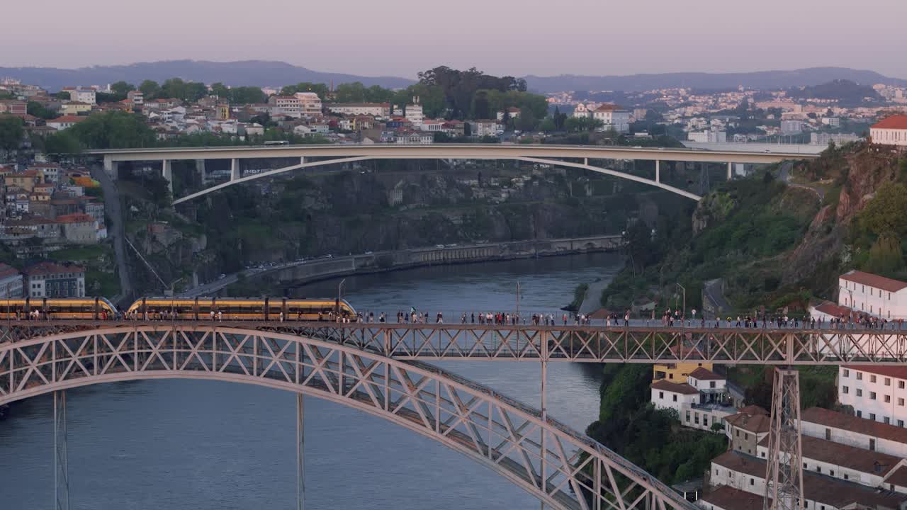 Cinematic drone view of Luís I Bridge with train passing by