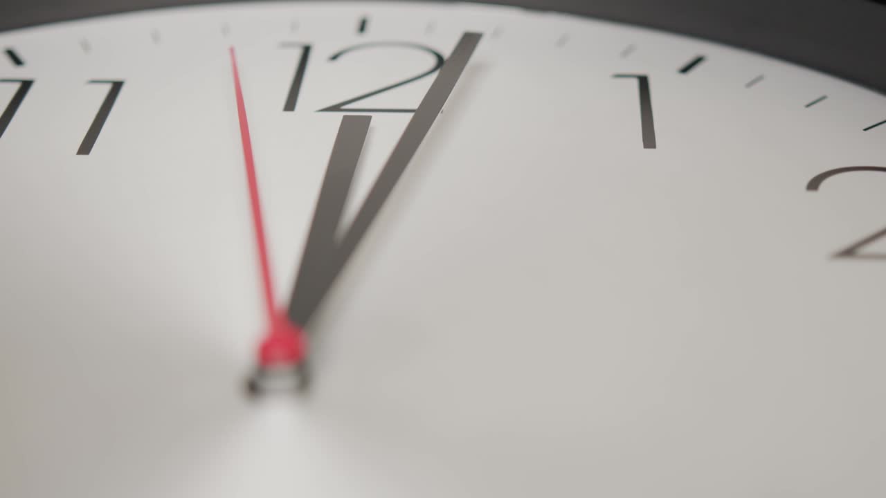 de cerca, el reloj blanco de la pared muestra el paso lento del tiempo.