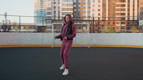 strength trainer jogging around sports court in urban setting amid towering highrise buildings under sunset sky while maintaining steady pace and focus during outdoor exercise session