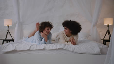 una pareja feliz hablando en la cama.