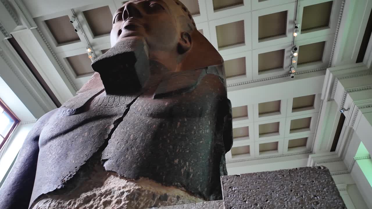 Orbital and detailed shot in 4k of an Egyptian sphinx displayed inside the British Museum in London, highlighting texture, craftsmanship, and ancient artistic heritage