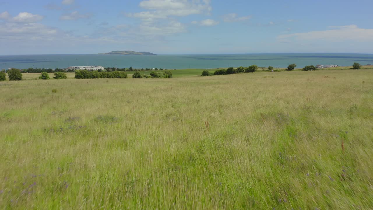 4k вперед низко над полем, затем поднять вверх, чтобы показать береговую линию