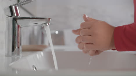 niño lavando las manos en el baño