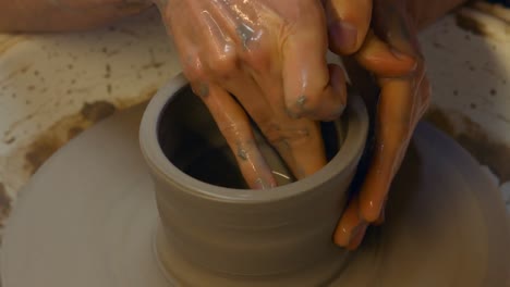 potter making a earthen pot on a pottery wheel