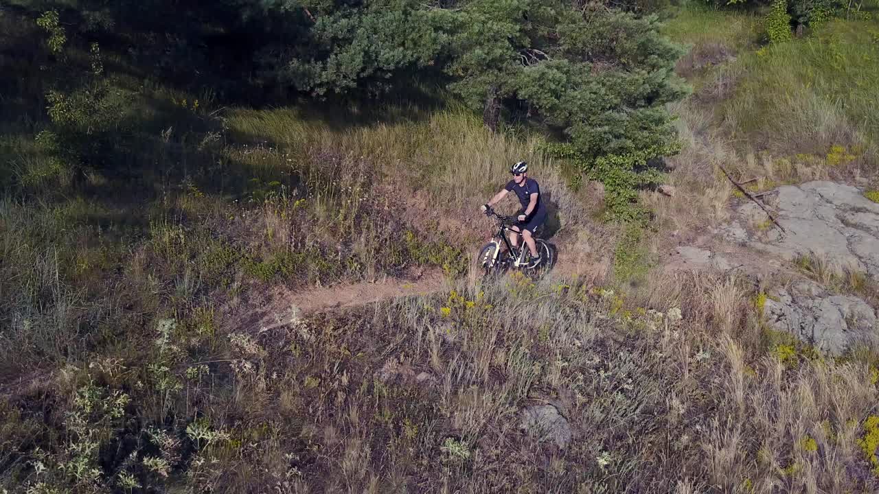 Two Friends Ride Bike. View of cyclist riding mountain bike on rocky trail near river