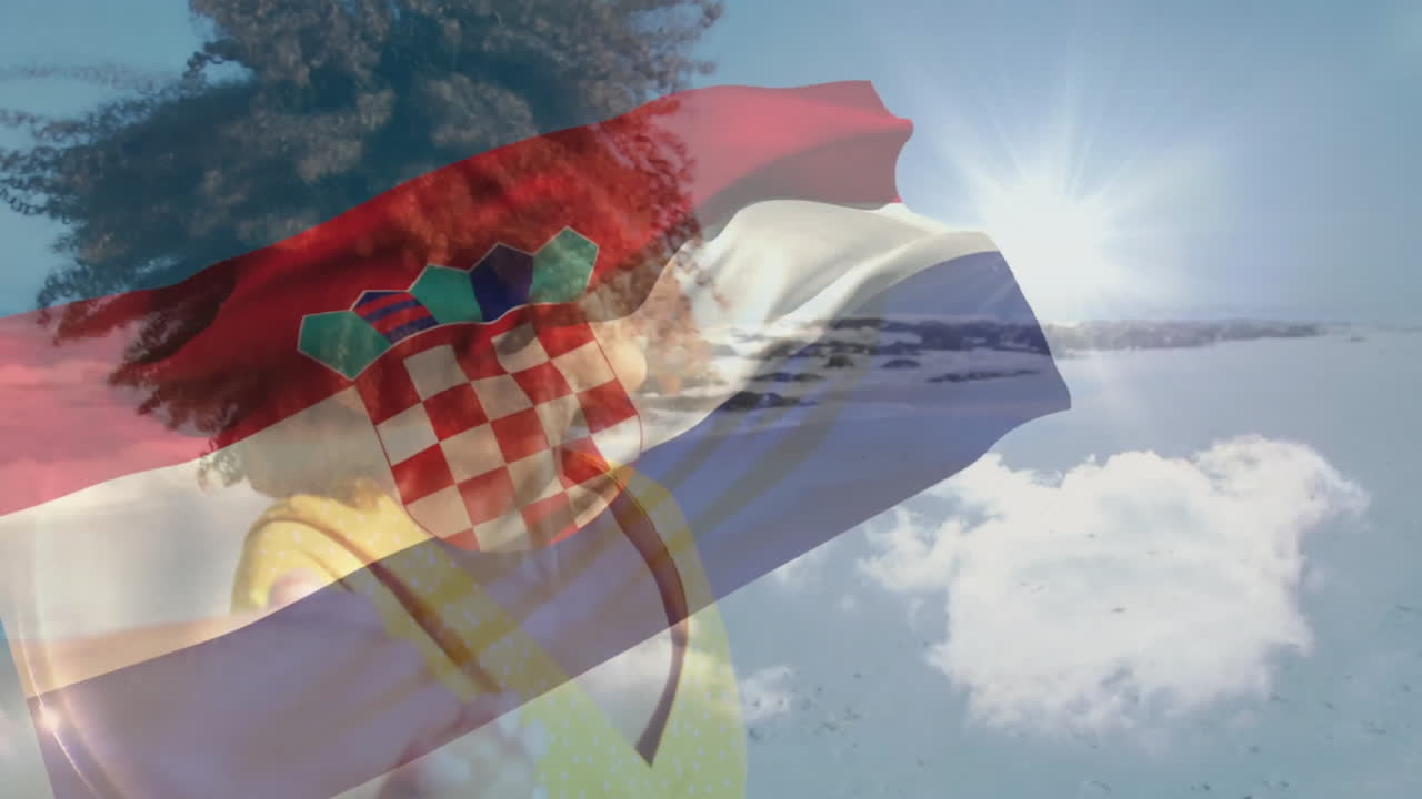 Croatian flag waving over person admiring snowy mountain landscape in winter
