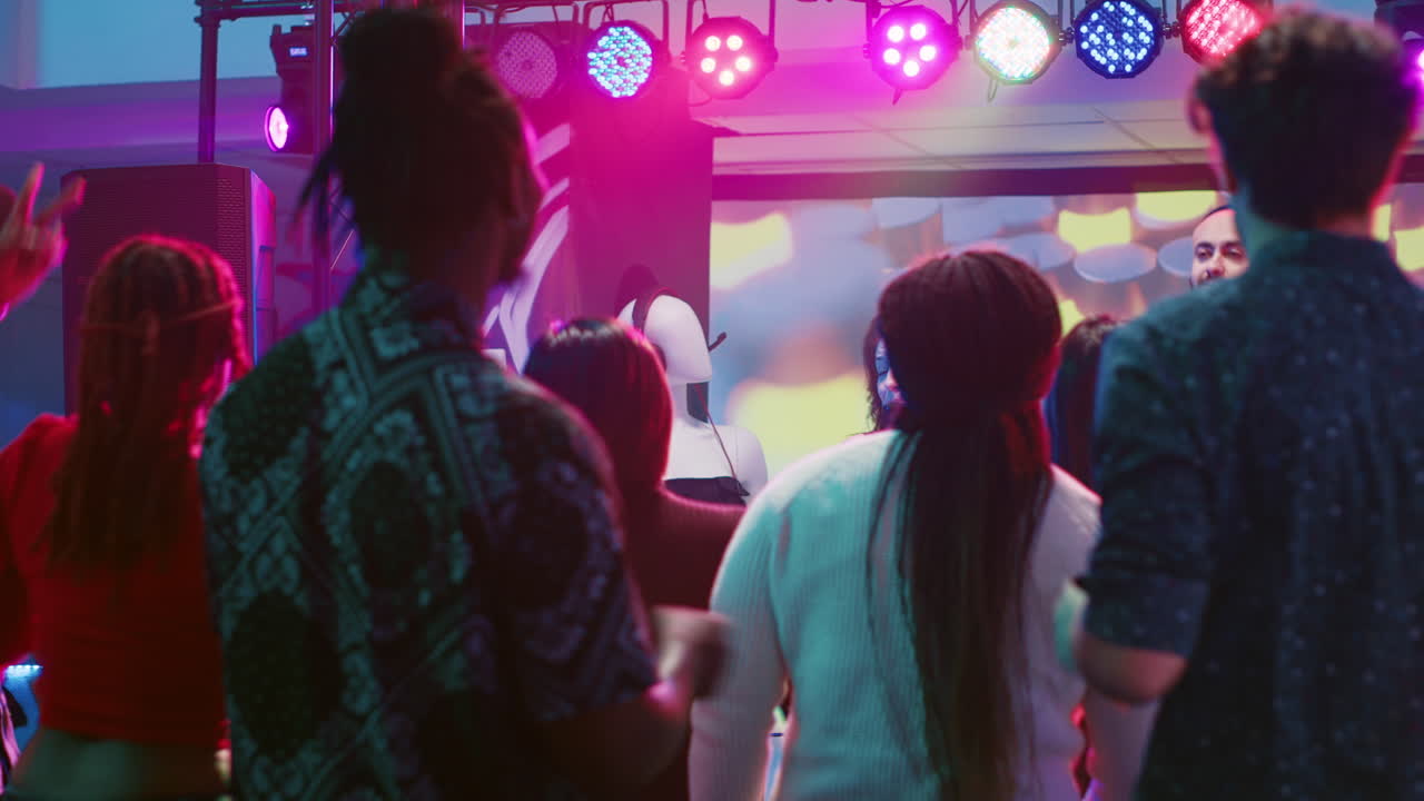 People enjoying a party in a nightclub with DJ and stage lights