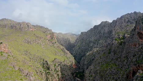 Estrecho-Desfiladero-Entre-Dos-Acantilados-Vasto-Paisaje-Montañoso-Con-Cielo-Atmosférico-Y-Vistas-Panorámicas