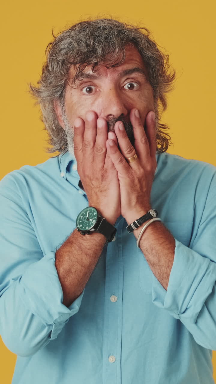 Mature Man Reacts with Shock and Covers His Mouth