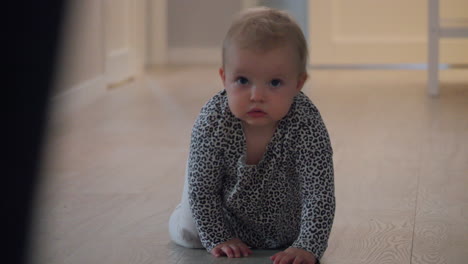 baby crawling on floor at home, mother running forward