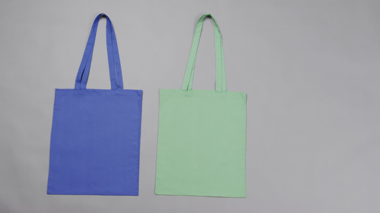 primer plano de bolsas azules y verdes sobre un fondo gris, con espacio de copia, cámara lenta